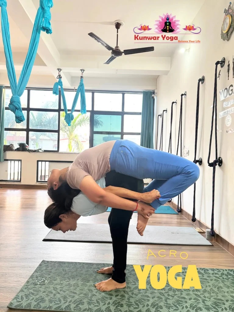 Acro Yoga instructors teaching partner inversion pose at Kunwar Yoga studio in Dehradun